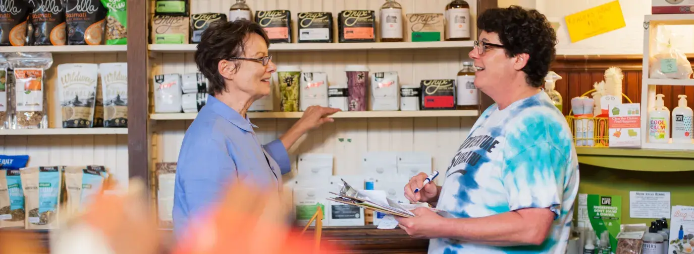 Shelley and Julie by the coffee and tea wall at The Green Corner Store. Organic tea.